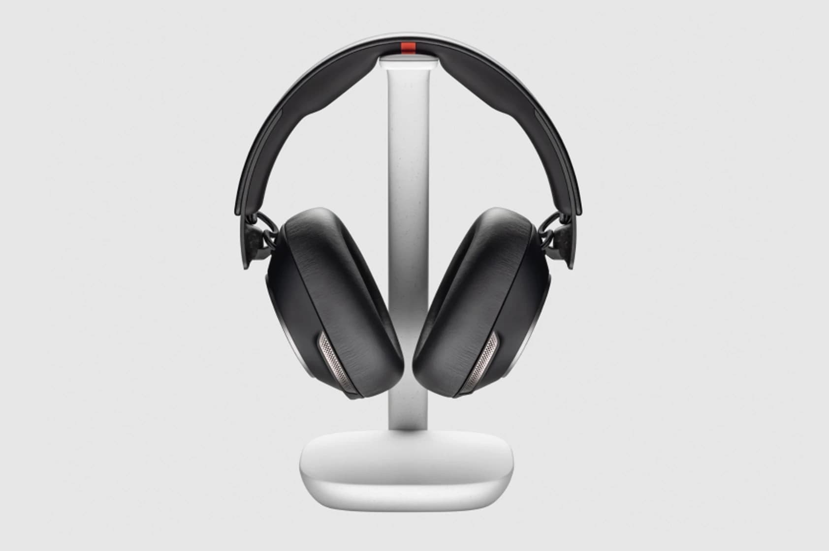 Poly Voyager Surround 85 UC headset on its wireless NFC charge stand, front view