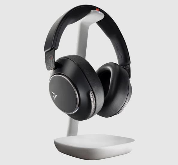 Poly Voyager Surround 85 UC headset on its charge stand, angled studio view
