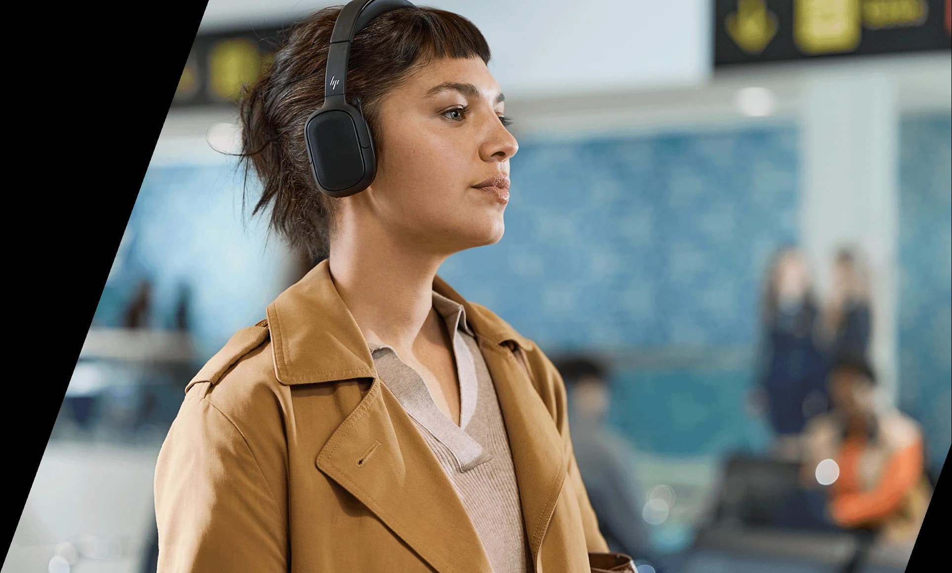 HP Poly Focus 625 Fold headset worn at an airport, demonstrating its foldable travel design