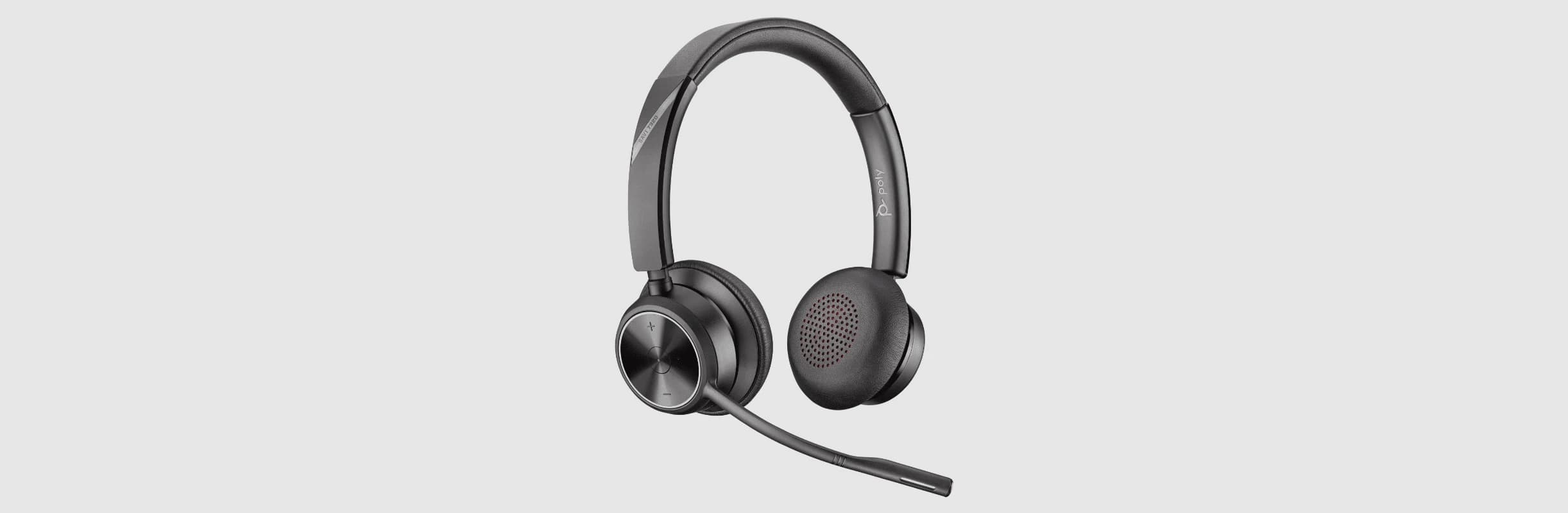 Poly Savi 7320 UC Stereo DECT headset on its charging stand, angled studio view