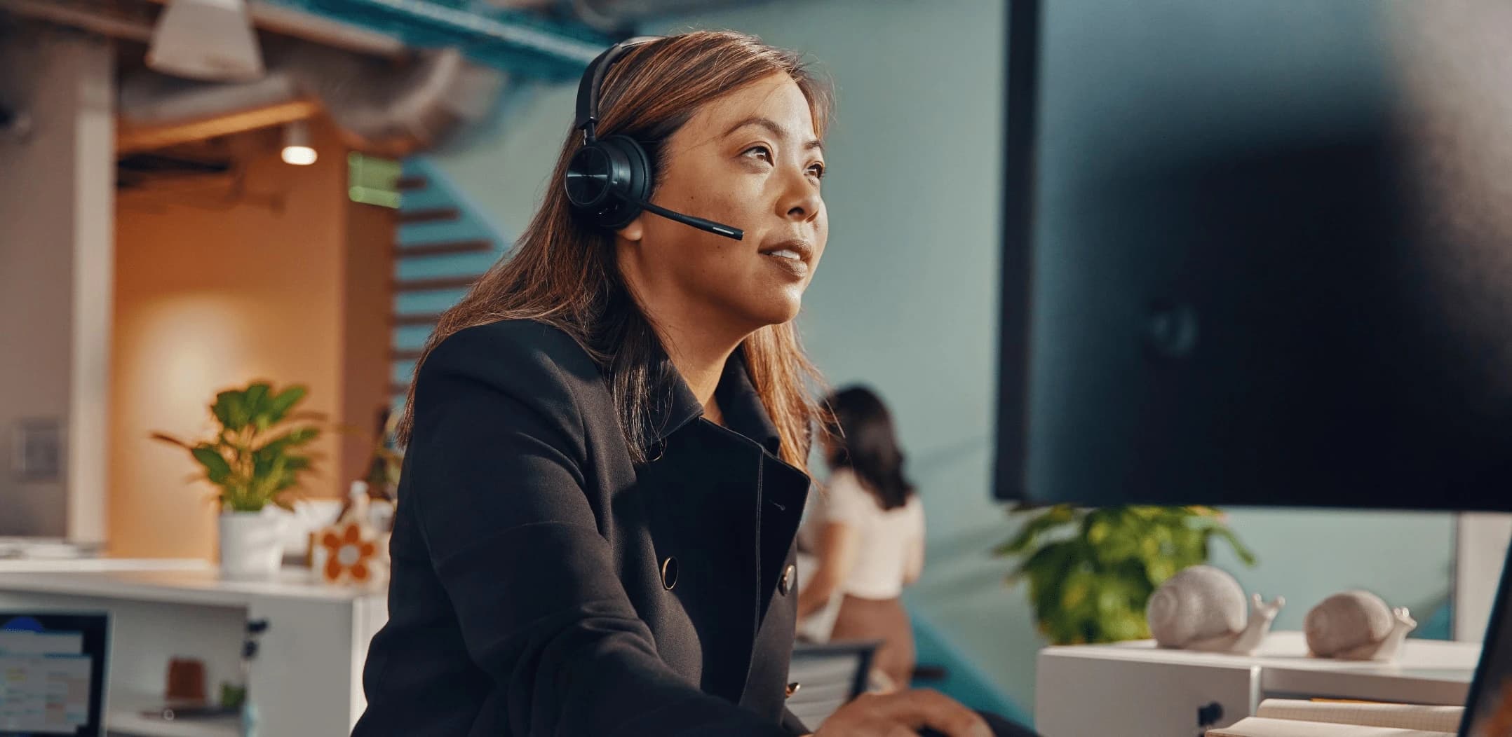 Poly Savi 7320 UC Stereo headset worn in an open-plan office