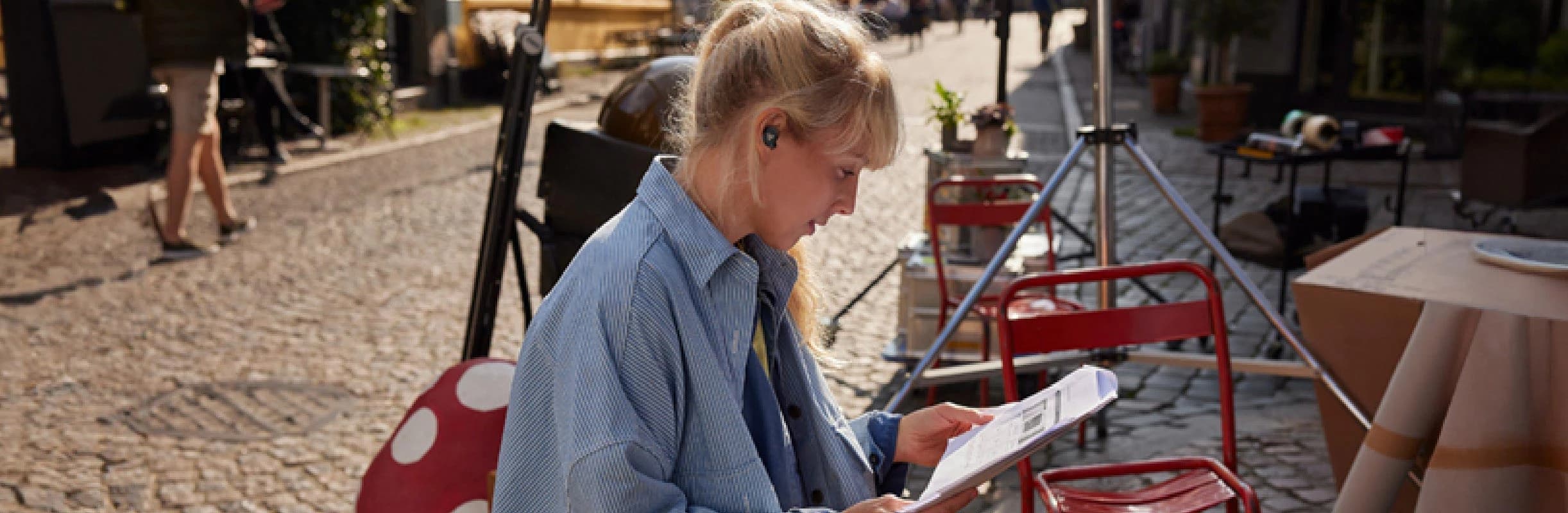 Poly Voyager Free 20 earbud worn by a person indoors