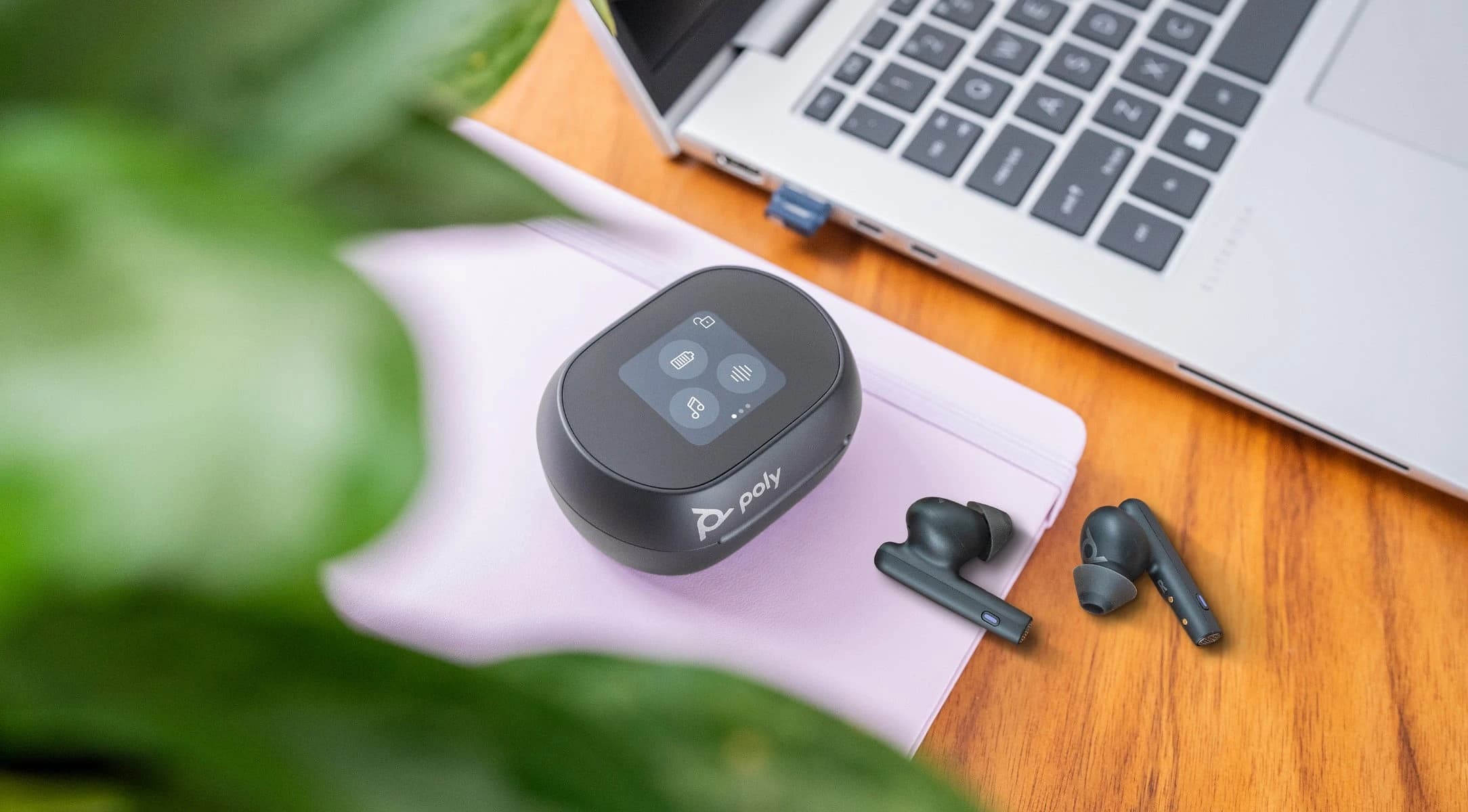 Poly Voyager Free 60+ UC earbuds and touchscreen charge case on a desk