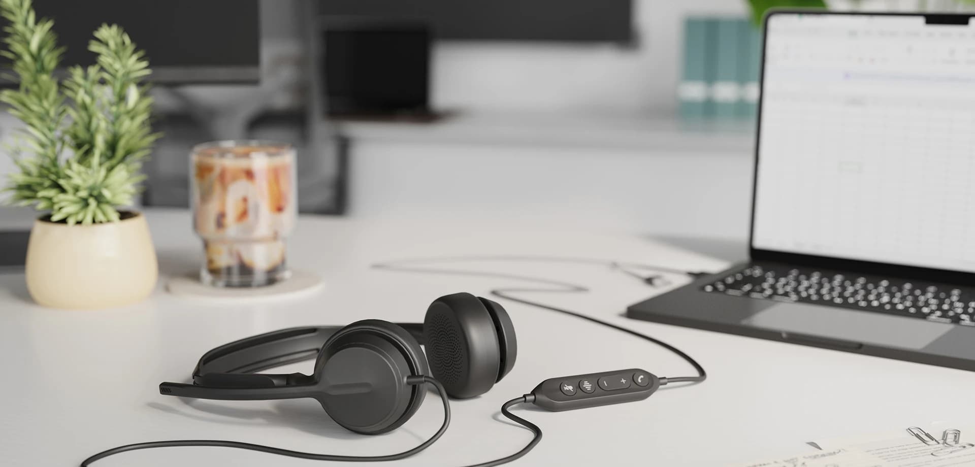 Yealink UH42 headset on a desk beside a laptop, connected via its in-line call controller